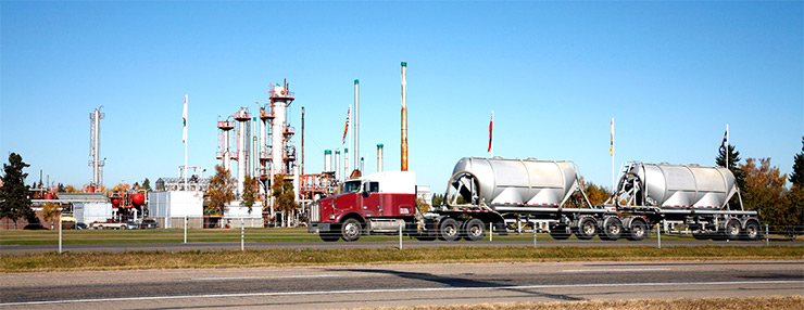 Raffinerie et chargement d’un gros camion-citerne de produits pétroliers raffinés par beau temps